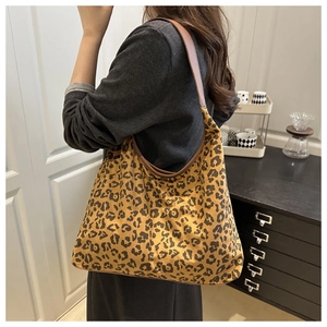 Close-up of leopard print hobo bag with brown leather strap in a home setting