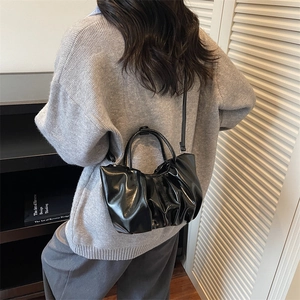 Glossy black ruched cloud handbag with top handle and crossbody strap for women