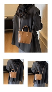 Detail of a brown leather tote bag showing the top handles and adjustable shoulder strap