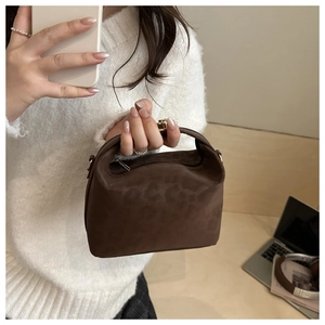 Detail of dark brown leopard embossed handbag with gold zipper and adjustable strap