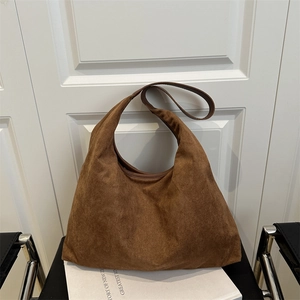 Brown suede large tote bag minimalist shoulder handbag displayed on white books