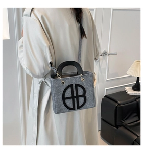 Sac fourre-tout moderne en feutre gris avec logo circulaire noir, vue arrière lifestyle