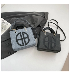 Détail de sacs en denim gris-bleu et noirs avec logo BB et finitions dorées sur tissu