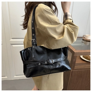 Detail of vintage black soft PU tote bag featuring silver eyelet straps and buckles