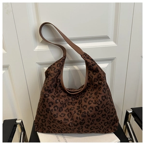 Detail of vintage leopard print tote bag on white prop books with classic wooden door background