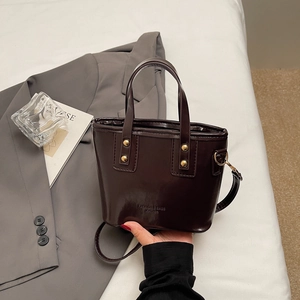Minimalist large capacity dark brown leather crossbody bag with rivet details and shoulder strap
