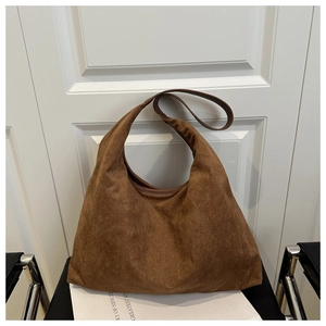 Detail showing the matte suede texture and Hobo style design of the brown tote bag