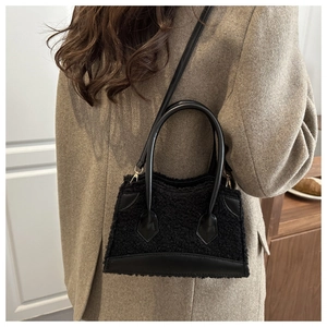 Détail du sac à main en fourrure noire avec bordure cuir et ferrures dorées