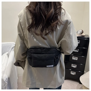 Vue de dos du mannequin portant un sac bandoulière en nylon noir avec sangle réglable