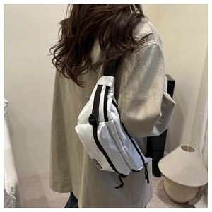 Sac de poitrine en nylon blanc avec fermetures noires porté par un mannequin stylé