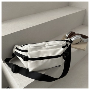 Détail d'un sac de poitrine en nylon blanc avec sangle noire réglable et logo de marque