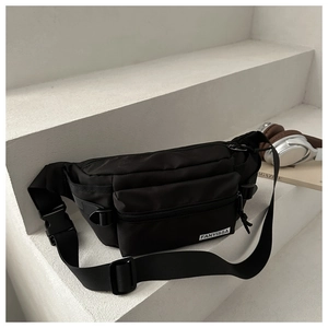 Gros plan du sac de poitrine en nylon noir imperméable avec poches et sangle réglable