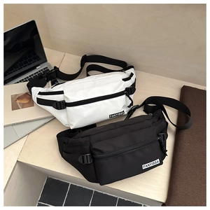 Détail de sacs bandoulière minimalistes en nylon noir et blanc sur un bureau moderne