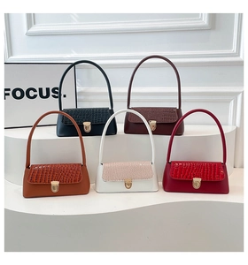 Close-up of vintage baguette bags in various colors with crocodile texture and gold lock