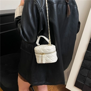 Mini quilted leather bucket bag with gold chain strap shown on a black leather jacket