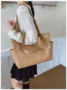 Detailed side view of camel quilted tote bag with side pocket and drawstring decor