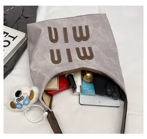 Spacious interior of grey tote bag showing organized storage for tablet and cosmetics
