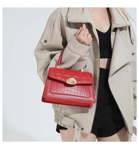 Vue détaillée du sac rouge avec texture matelassée et motif crocodile sur un mannequin