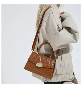Détail d'un sac à main marron avec matelassage en losanges et fermoir en forme de goutte