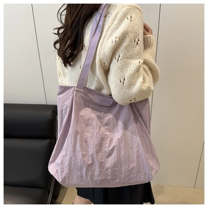 Détail du grand sac cabas en nylon violet clair avec étiquette et texture froissée