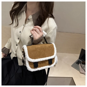 Detail of plush saddle bag featuring brown faux suede and white faux fur trim on a table