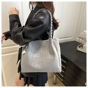 Détail du sac fourre-tout gris à motif léopard avec poignée tissée et foulard décoratif