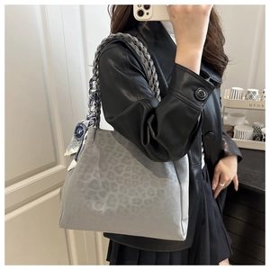 Detail of grey leopard print tote bag with woven strap and decorative blue silk scarf