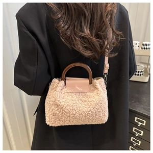 Détail du sac bandoulière rose en peluche avec poignées rondes en bois et sangle en cuir