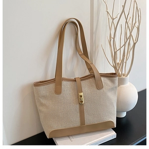 Detail of canvas tote bag with leather trim, golden hardware and reinforced corners