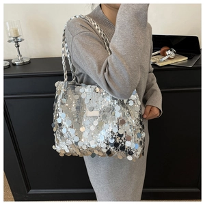 Detail of silver sequin tote bag with metallic logo plate and braided shoulder straps