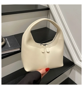 Detail of a minimalist cream PU leather hobo bag with dual zippers and decorative stitching