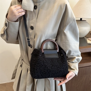 Sac seau minimaliste en polaire noire avec poignée en bois et bandoulière en cuir chic