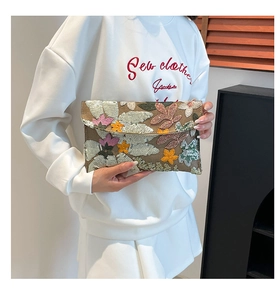 Detail of handmade sequined floral embroidery on brown envelope clutch bag for women