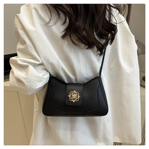 Detail view of a black retro shoulder bag featuring a vintage golden hollow buckle