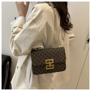 Detail of vintage monogram shoulder bag featuring a gold geometric buckle and chain strap