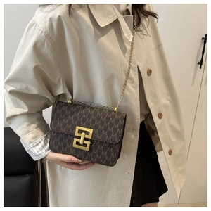 Detailed close-up of brown crossbody bag with M-letter print and gold metal buckle
