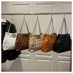 Detailed display of five color options for quilted tote bags with metal chain straps