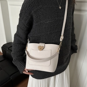 Fashionable off-white bucket bag with golden heart buckle and versatile straps