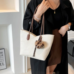 Off-white large capacity tote bag with brown handles and leopard pom-pom accessory