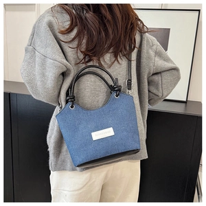 Détail du sac seau en denim avec poignée en cuir contrastée et patch Fashion & Bags