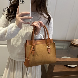 Elegant brown suede and faux leather handbag featuring a stylish top handle design