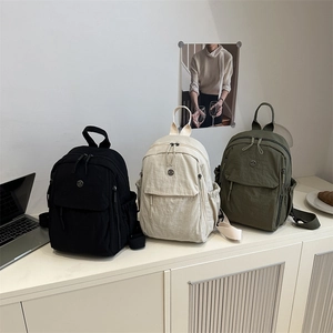 Trois sacs à dos en nylon minimalistes et légers en noir, blanc cassé et vert olive