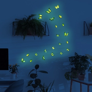 Glow-in-the-dark butterfly wall stickers emitting neon light in a dark bedroom setting