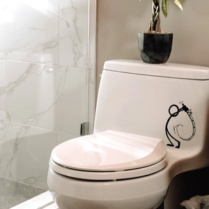 Close-up of minimalist stickman fishing sticker on white ceramic toilet tank surface