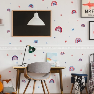 Rainbow and stars wall stickers applied on children room wall above a wooden desk