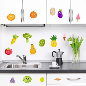 Cartoon fruit and vegetable wall decals applied to white kitchen cabinets and tiles