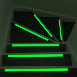 Glow in the dark photoluminescent anti-slip tape on dark wood stairs for safety