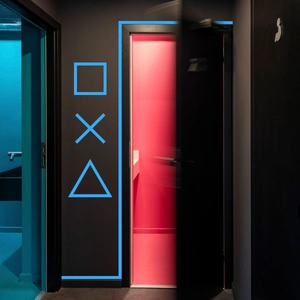 Luminous blue gaming icons on wall featuring square cross and triangle glow tape