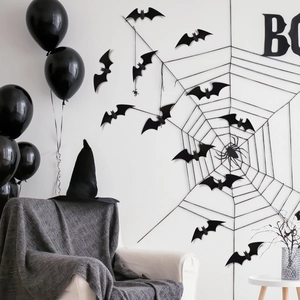 Detailansicht der Halloween-Fledermaus-Sticker und großes Spinnennetz auf weißer Wand