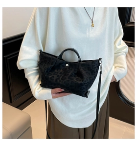 Close-up of leopard print tote bag featuring silver magnetic closure and detachable strap